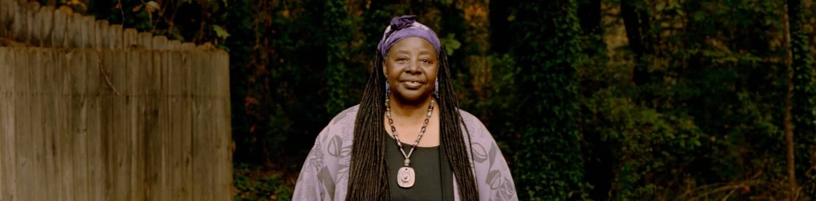 a person with long hair and a purple head wrap