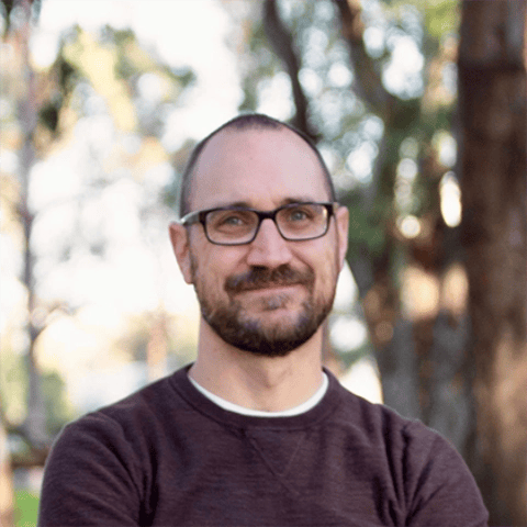 a person with glasses smiling