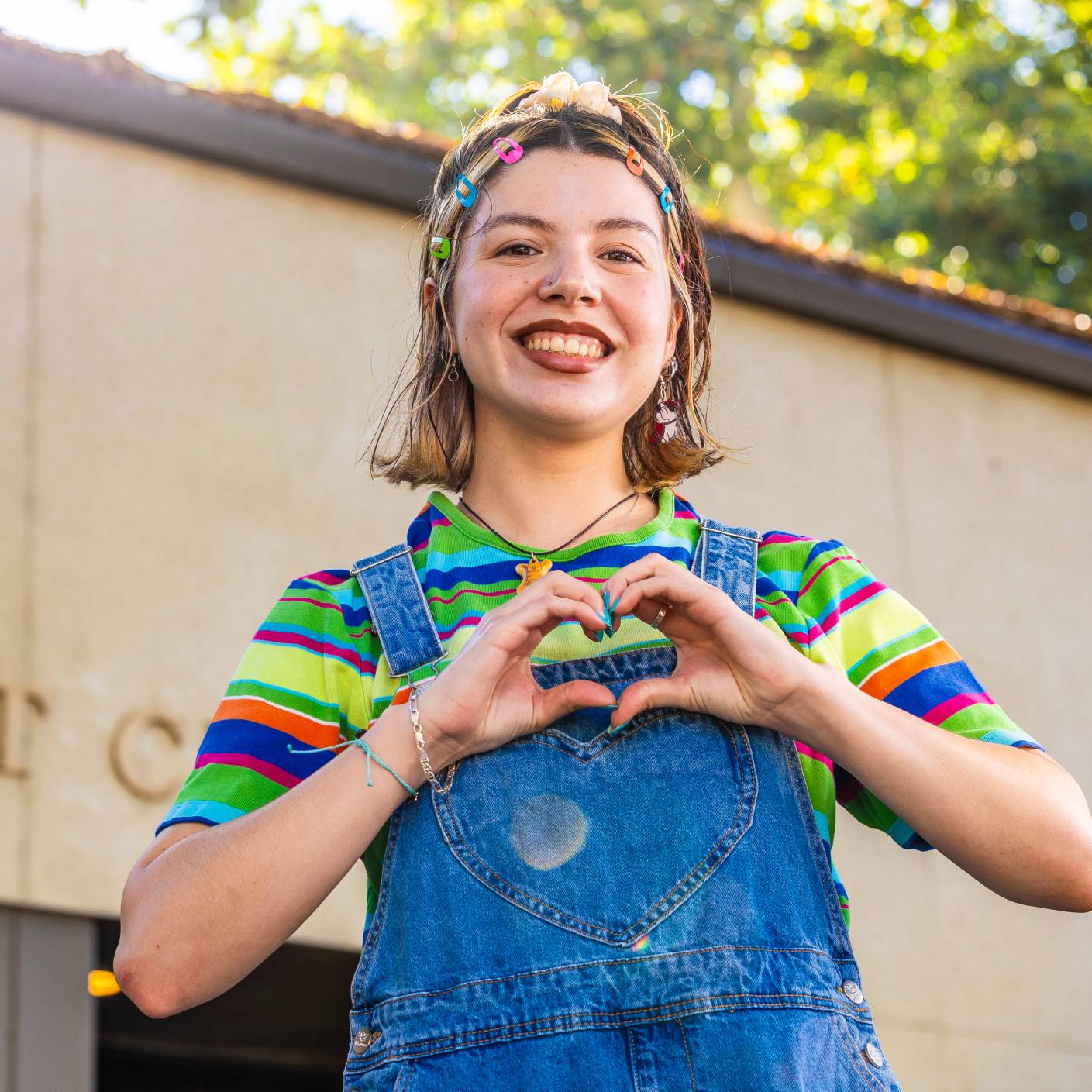 a child making a heart with her hands