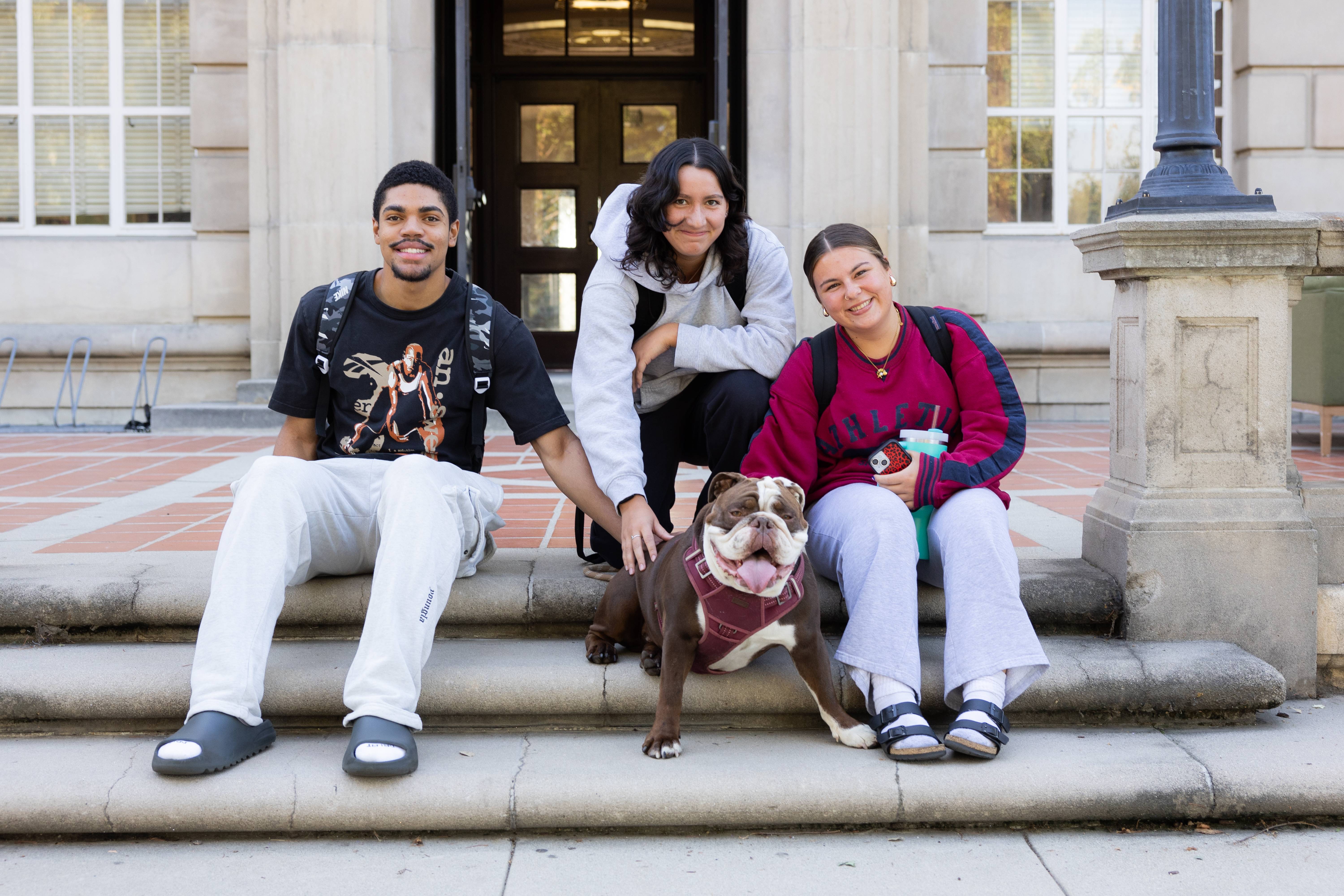 a group of people sitting on steps with a dog
