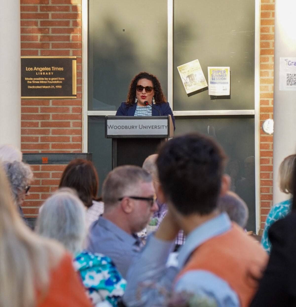 a person speaking into a podium in front of a crowd of people