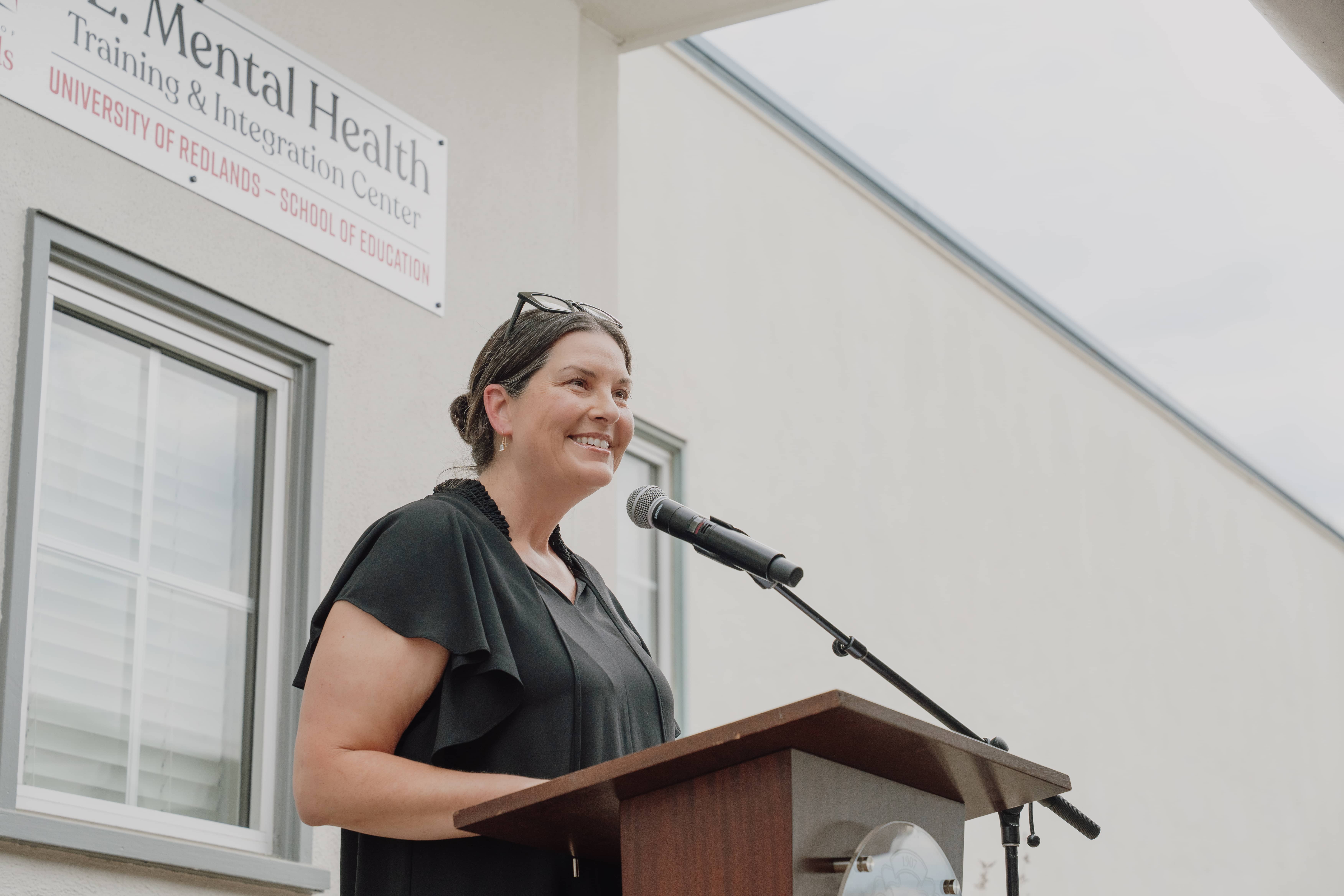 a person standing at a podium with a microphone