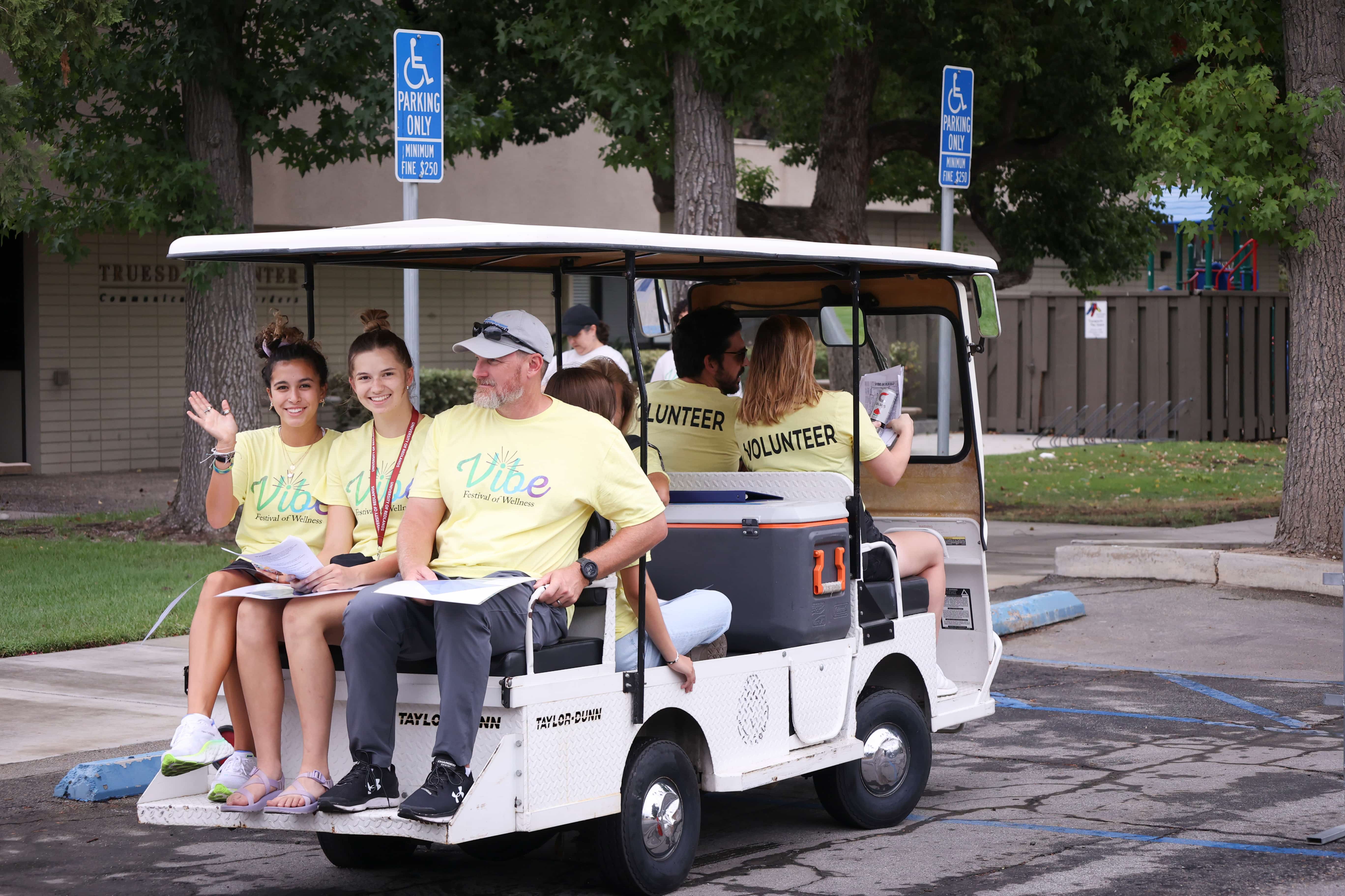 a group of people sitting in a golf cart