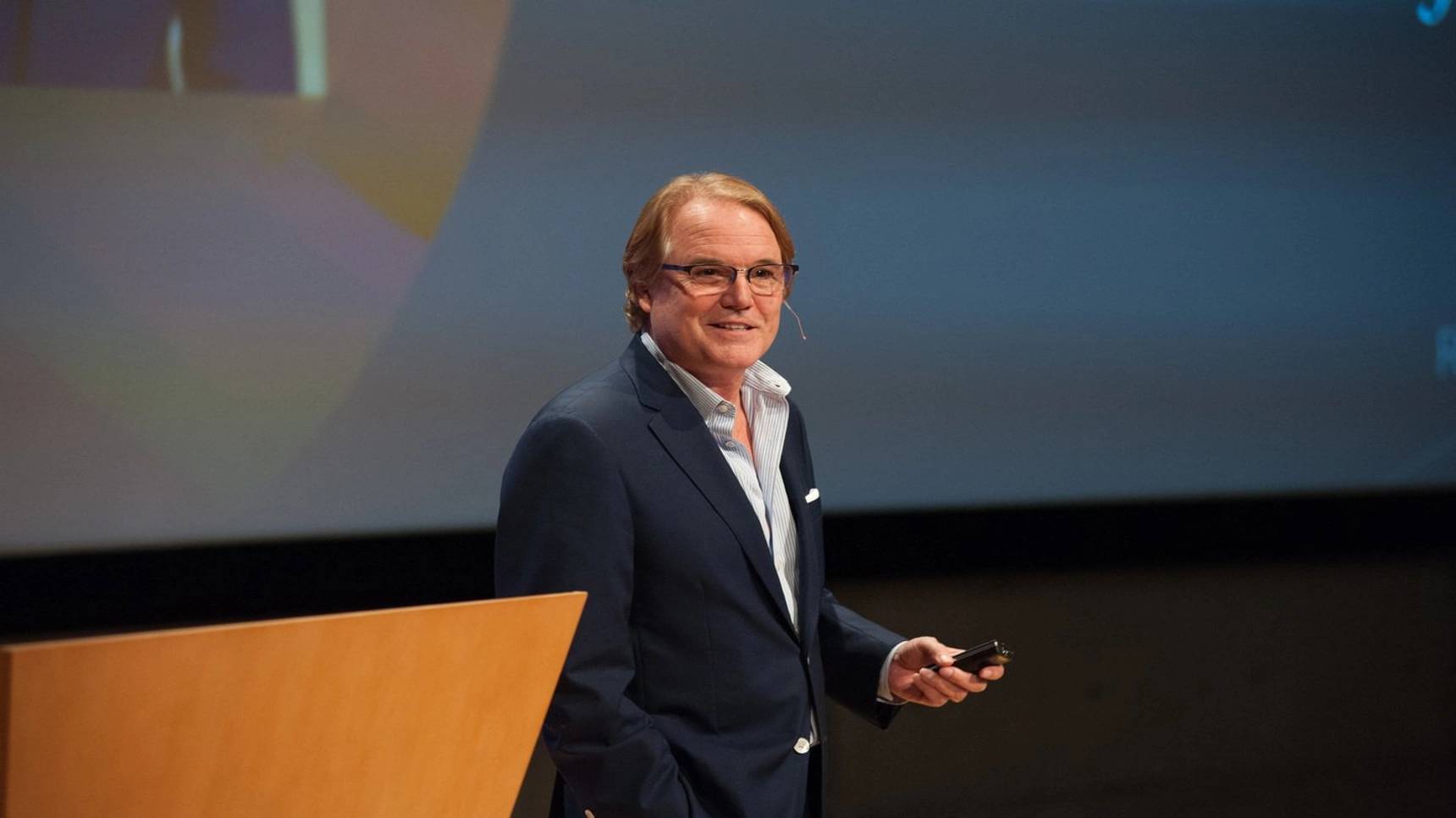 a person standing at a podium holding a phone