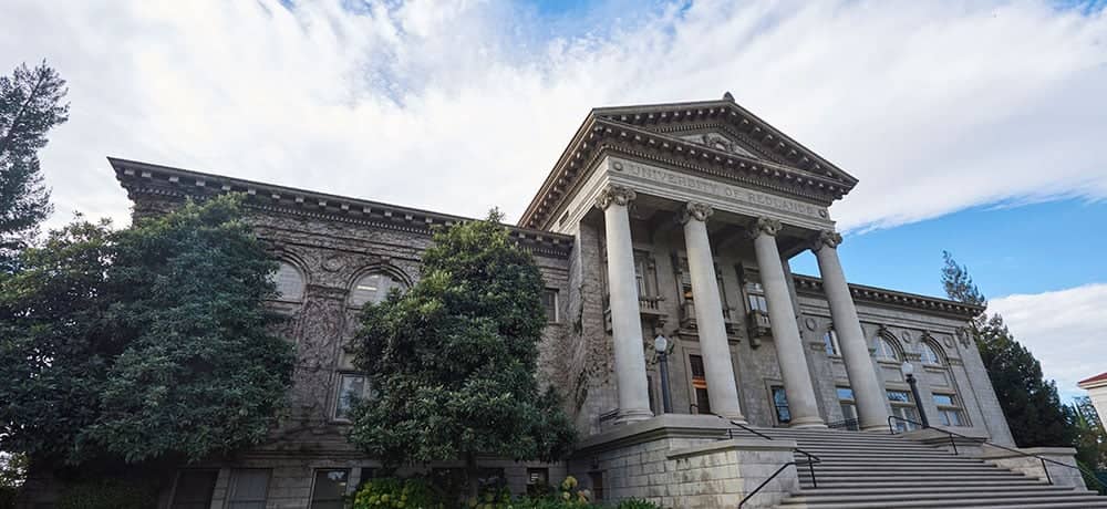 a building with columns and a tree