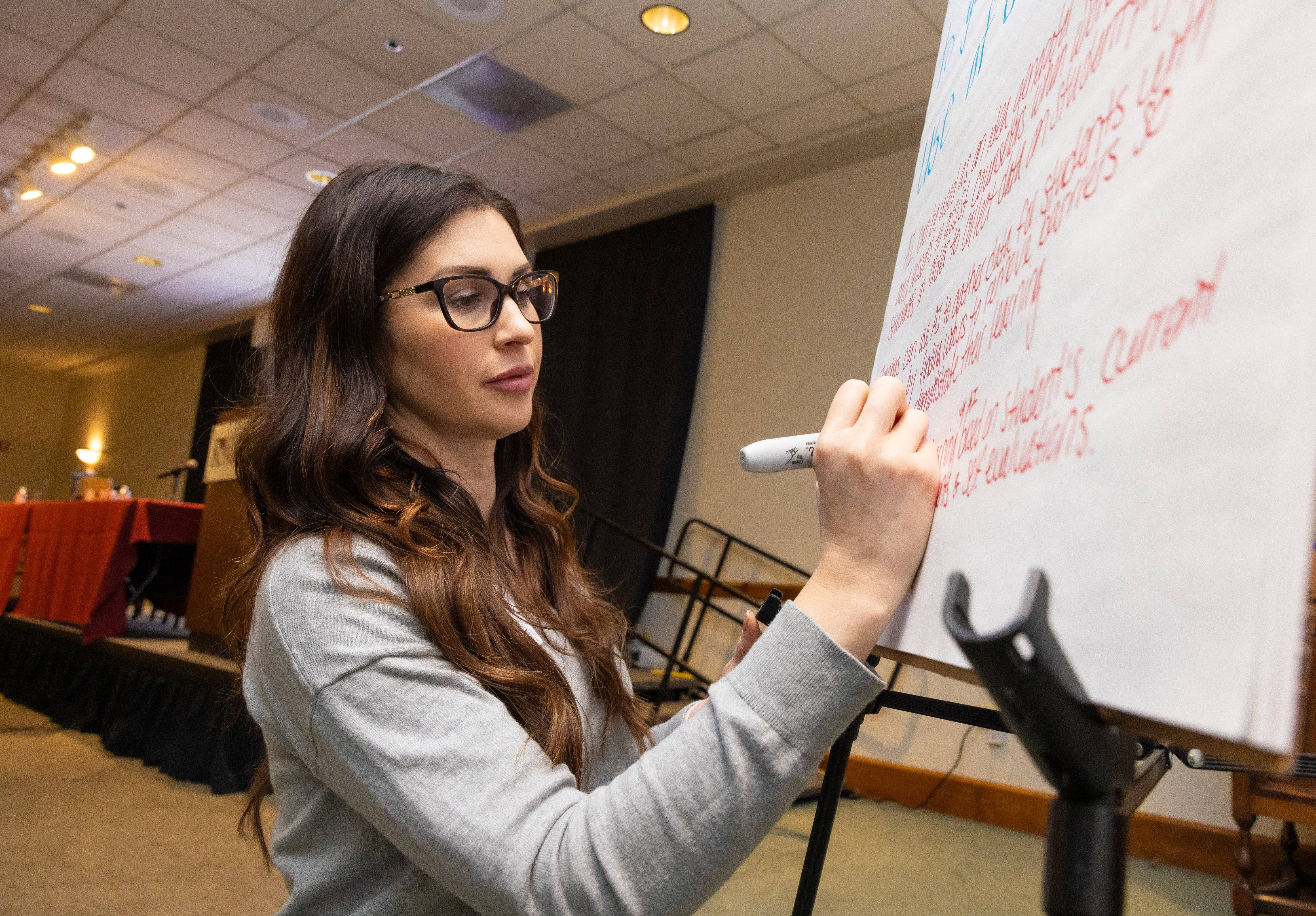 a person writing on a whiteboard
