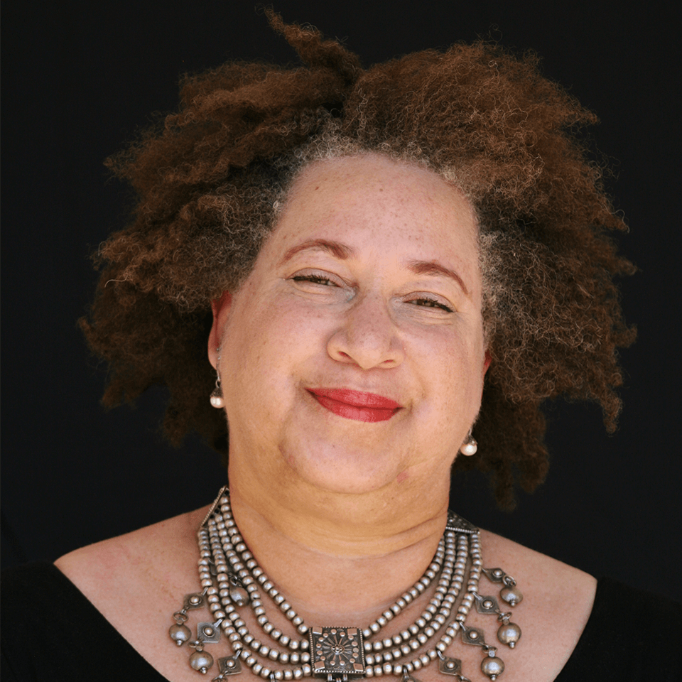 a person with curly hair wearing a necklace