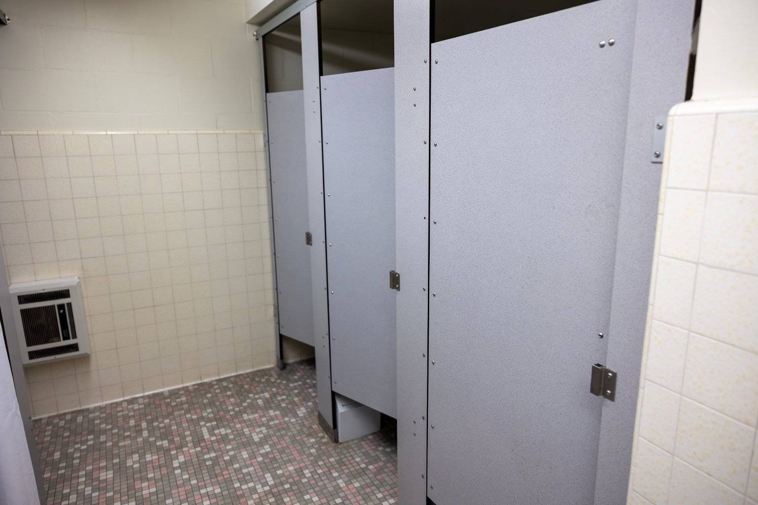 a row of grey doors in a bathroom