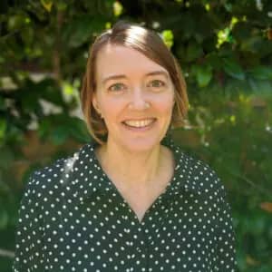 a person smiling in front of a tree