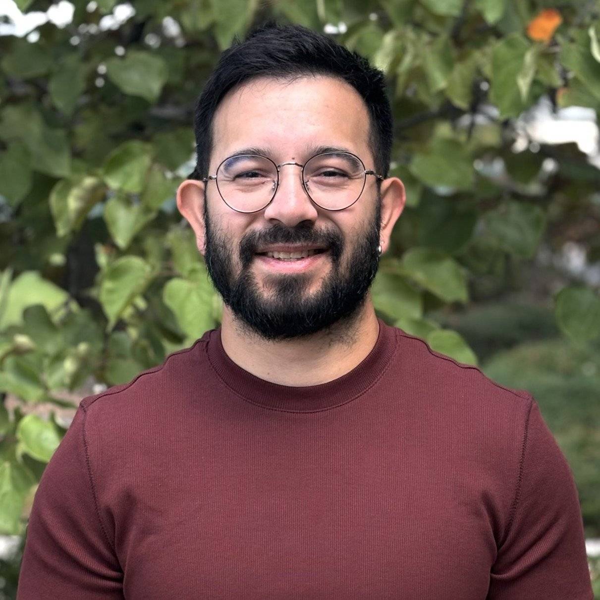 a person with beard and glasses smiling