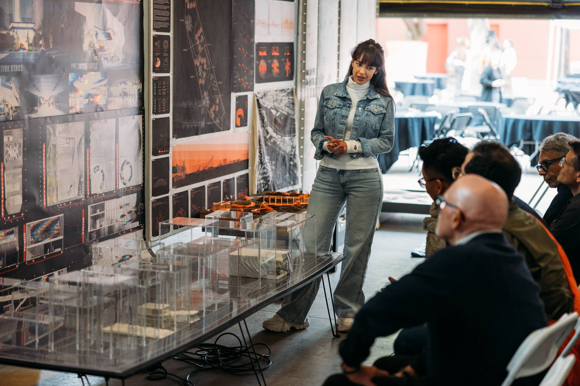 a person standing in front of a table with a display of glass