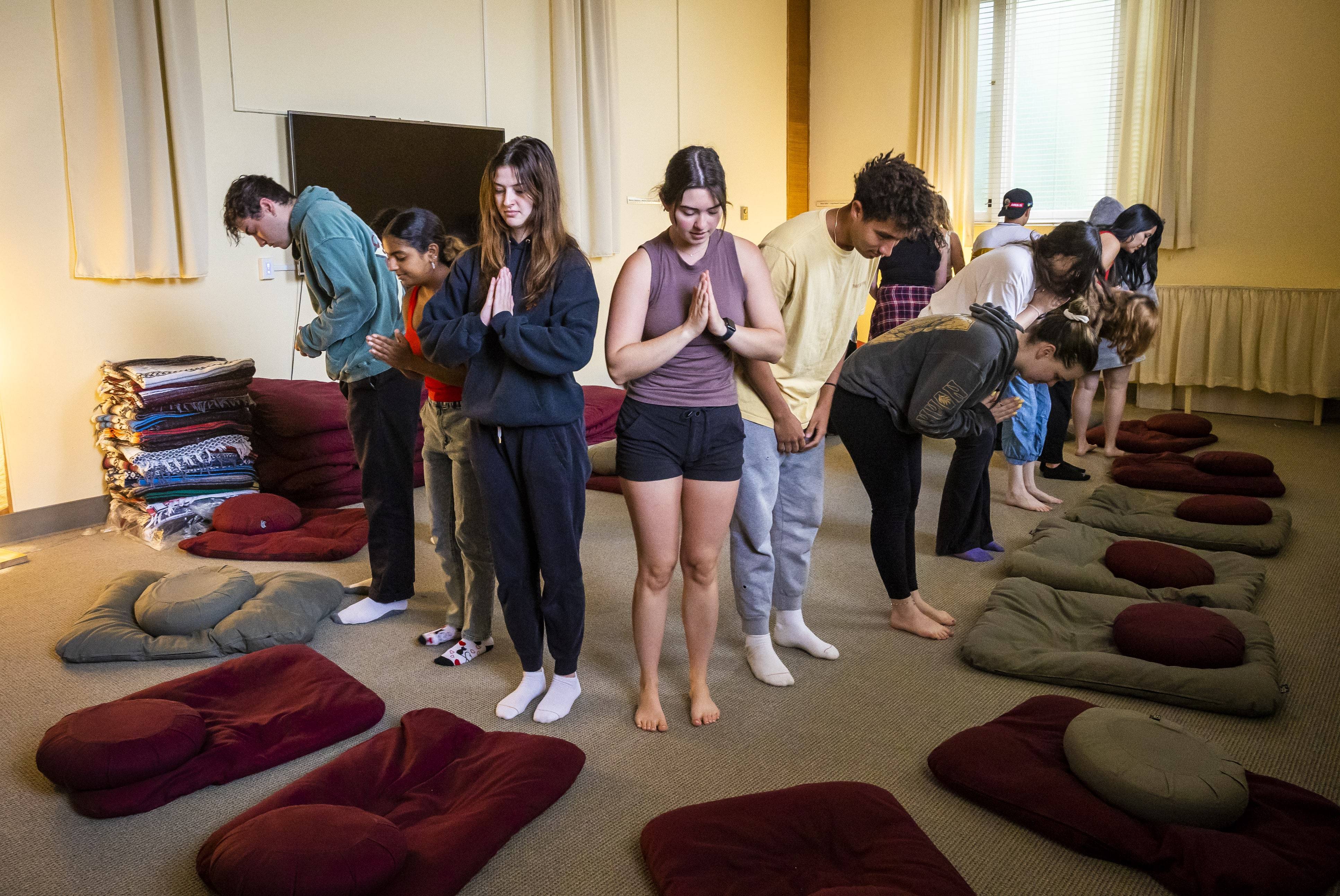 a group of people standing in a room with pillows