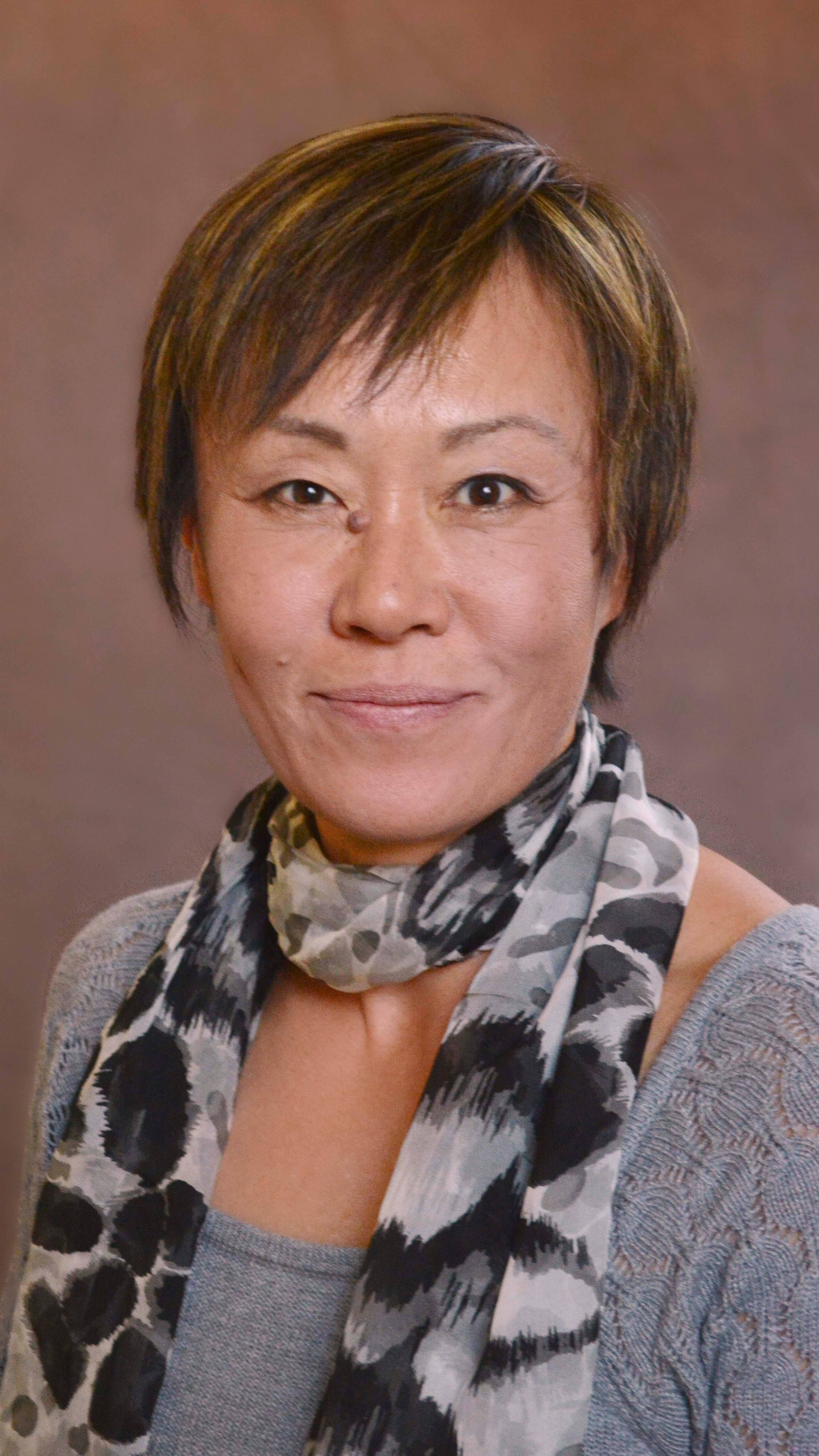 a person with short hair wearing a scarf