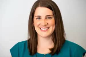 a person with brown hair wearing a teal shirt