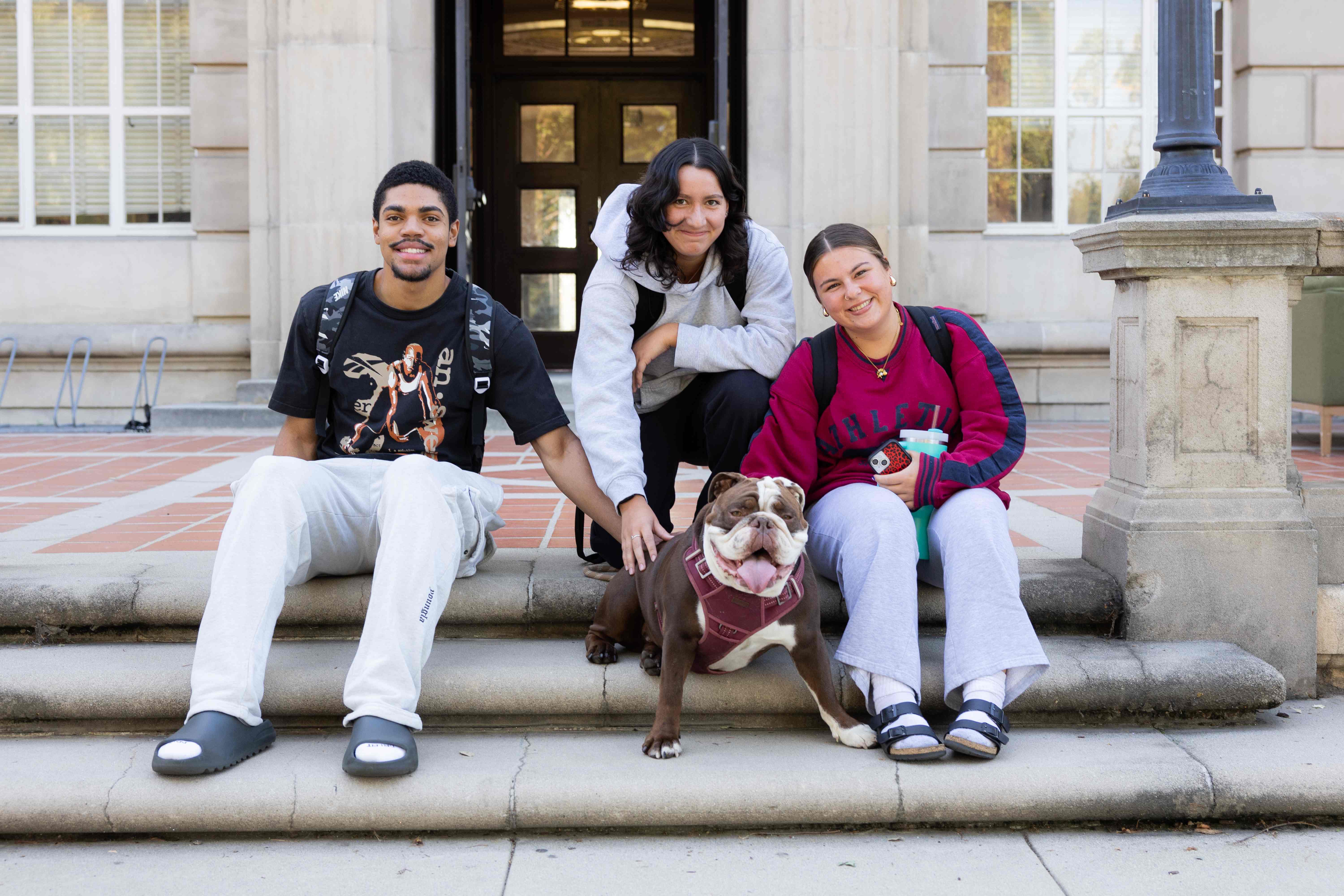 a group of people sitting on steps with a dog