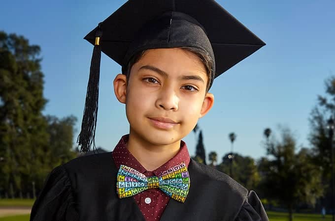 a child in a graduation gown and cap