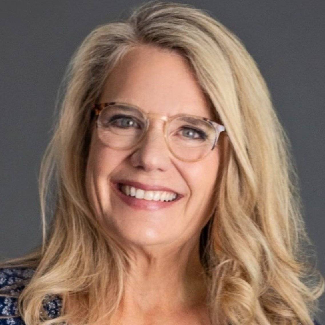 a person with blonde hair wearing glasses