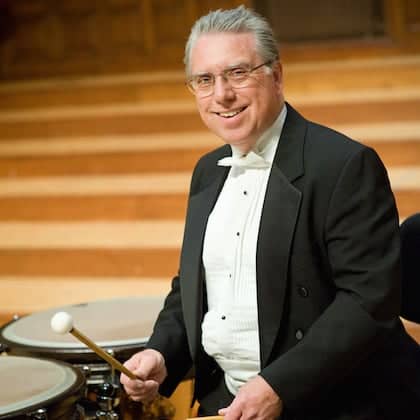 a person in a suit playing drums