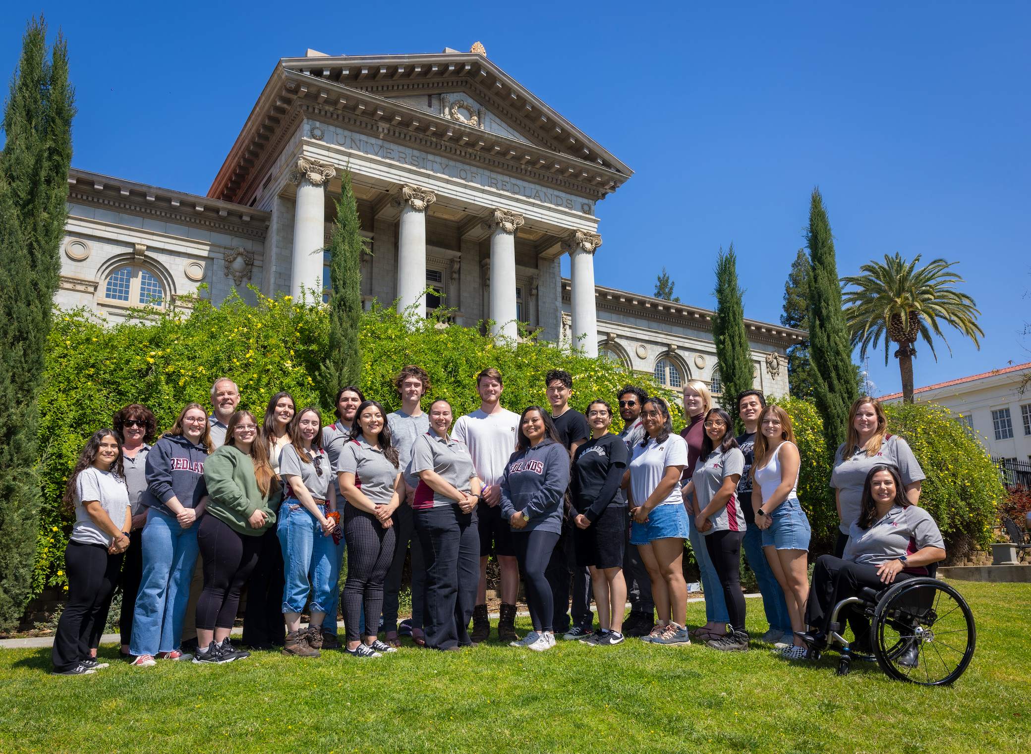a group of people posing for a photo in front of a building