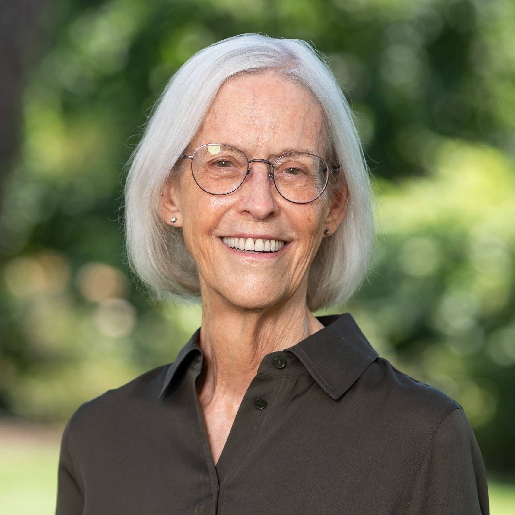 a person with glasses smiling