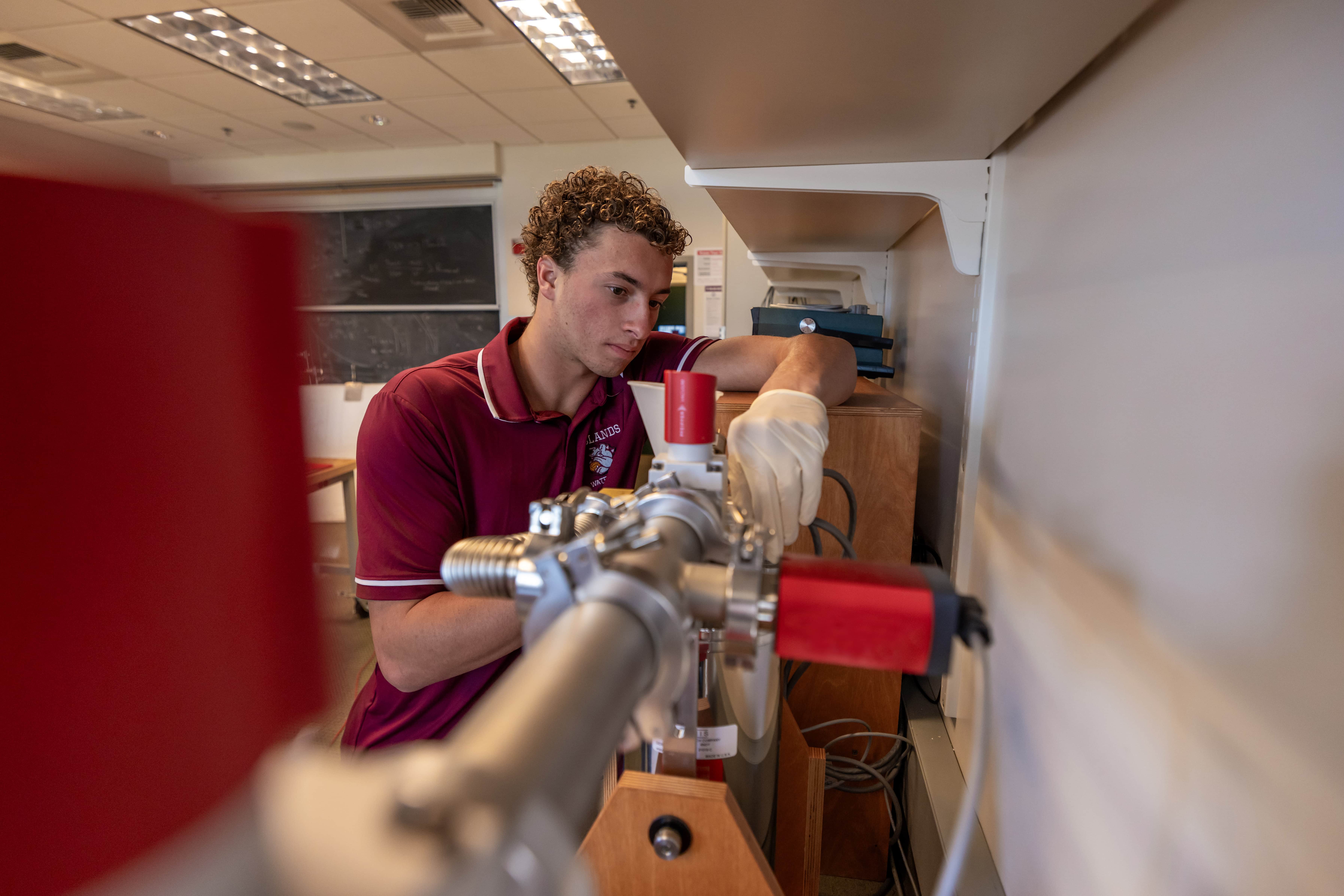 a person in a red shirt and gloves working on a machine