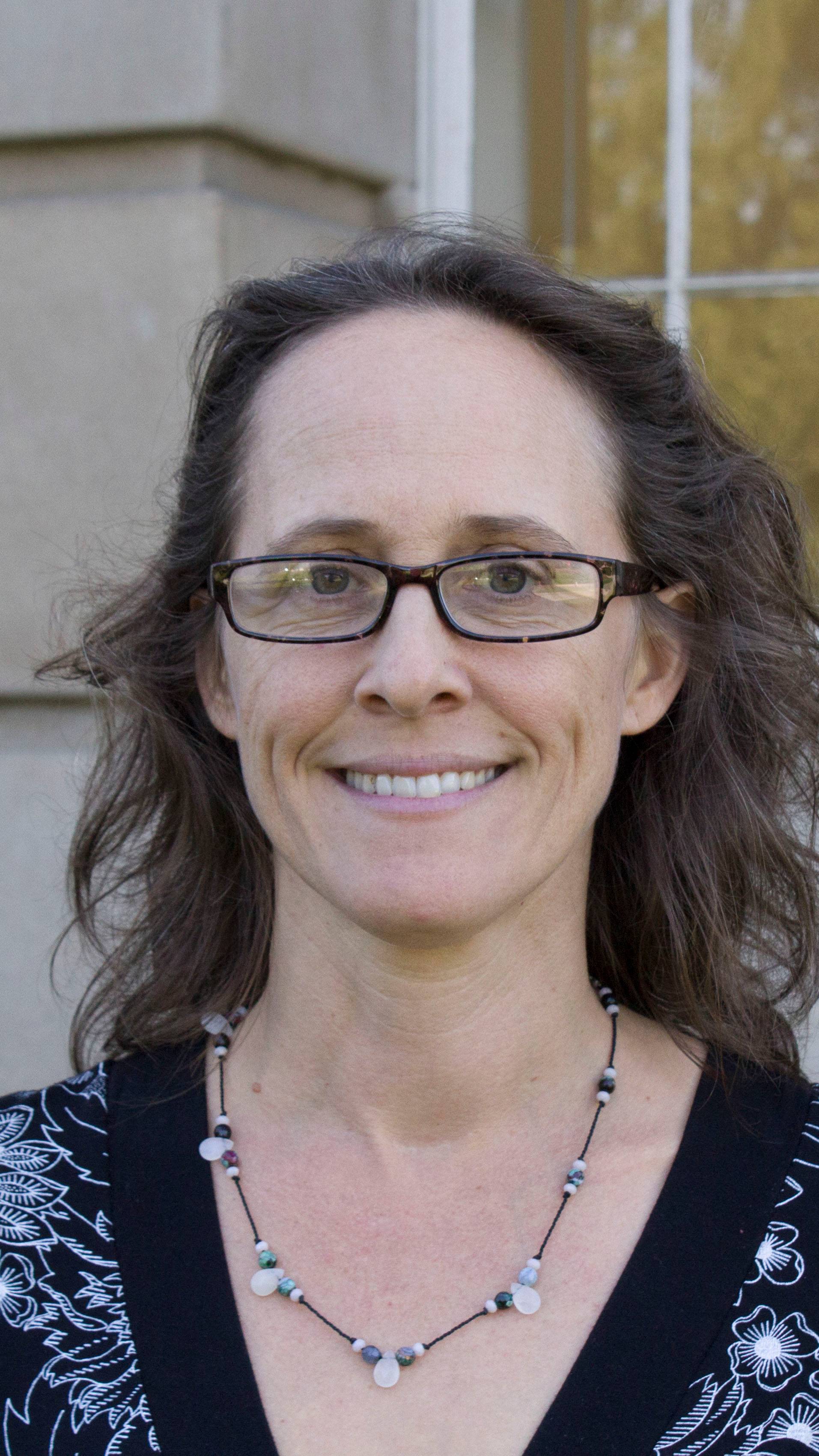 a person wearing glasses and smiling