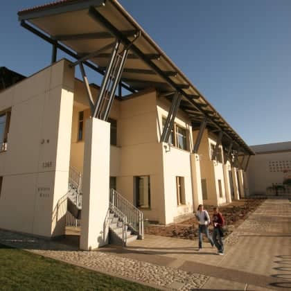 a couple of people walking in front of a building