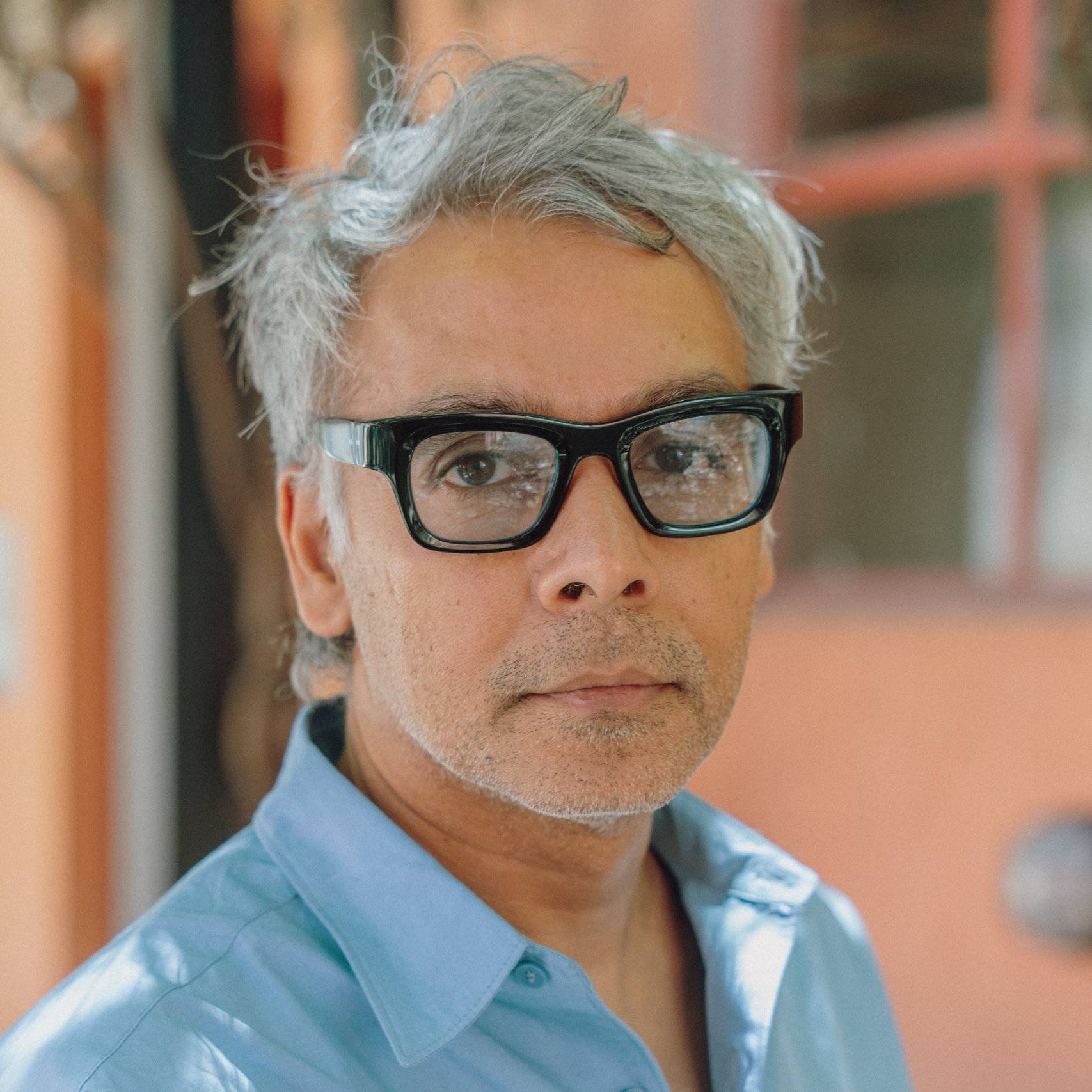 a person with glasses and a blue shirt