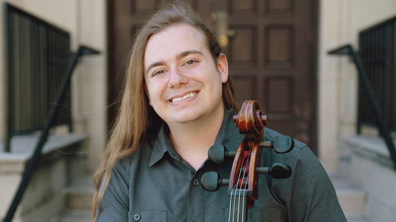 a person smiling with a violin