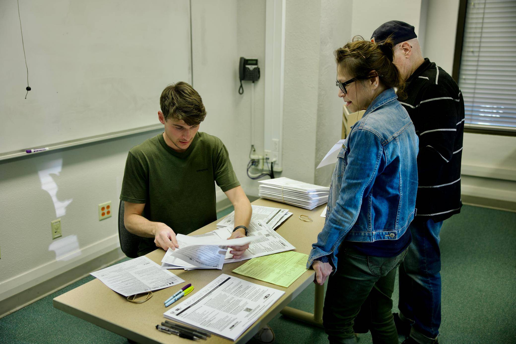 a group of people looking at papers on a table