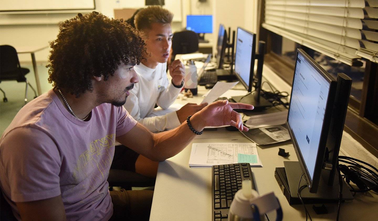 a group of men looking at a computer screen