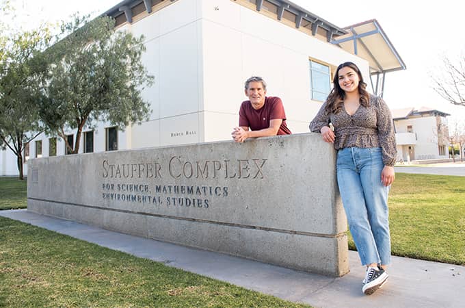 a person and person leaning on a stone wall