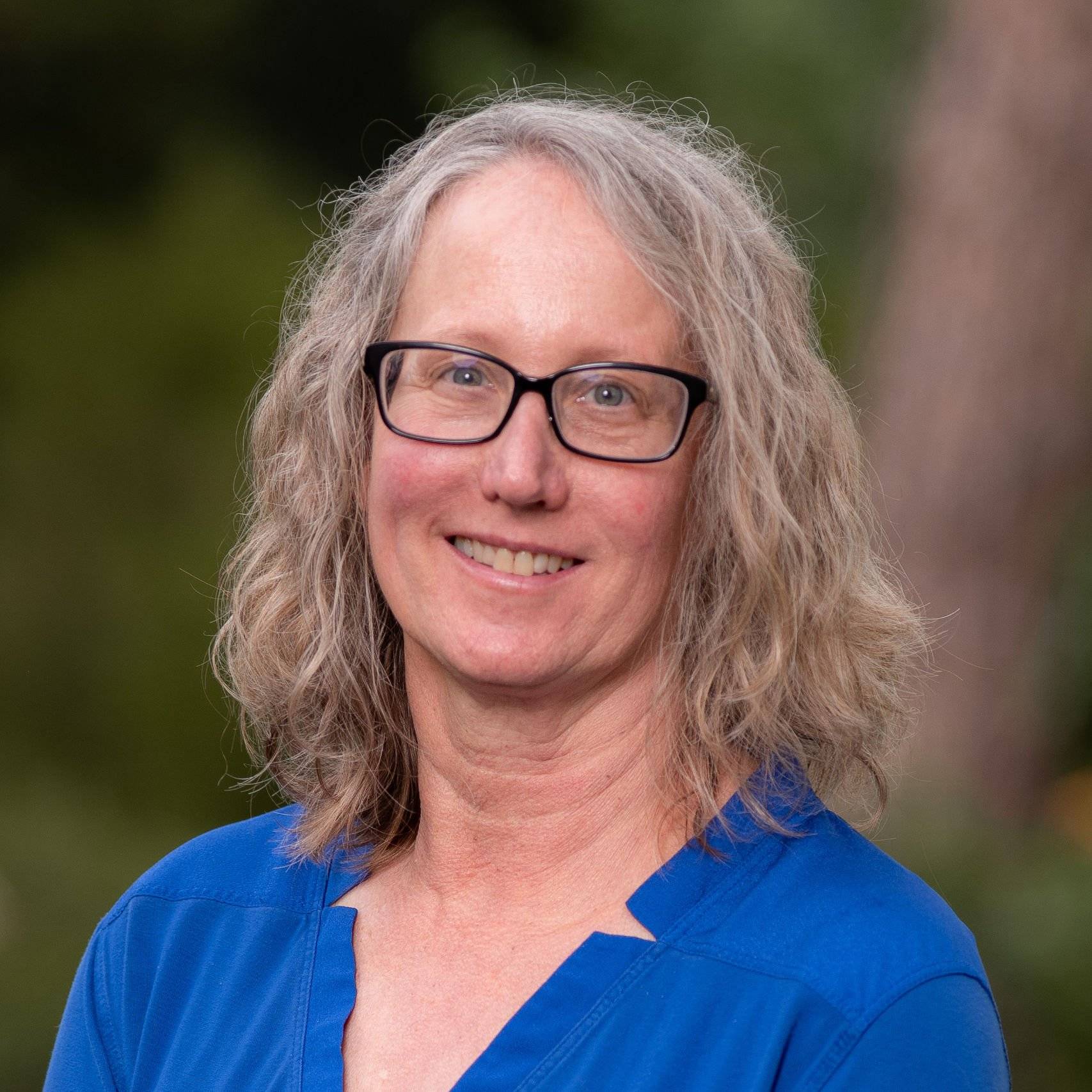 a person with glasses smiling