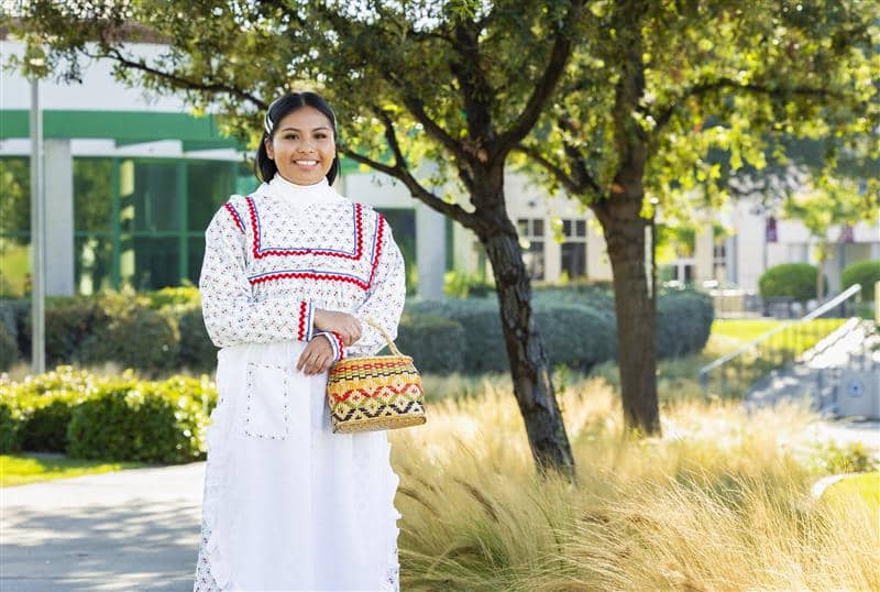 a person in a white dress holding a basket
