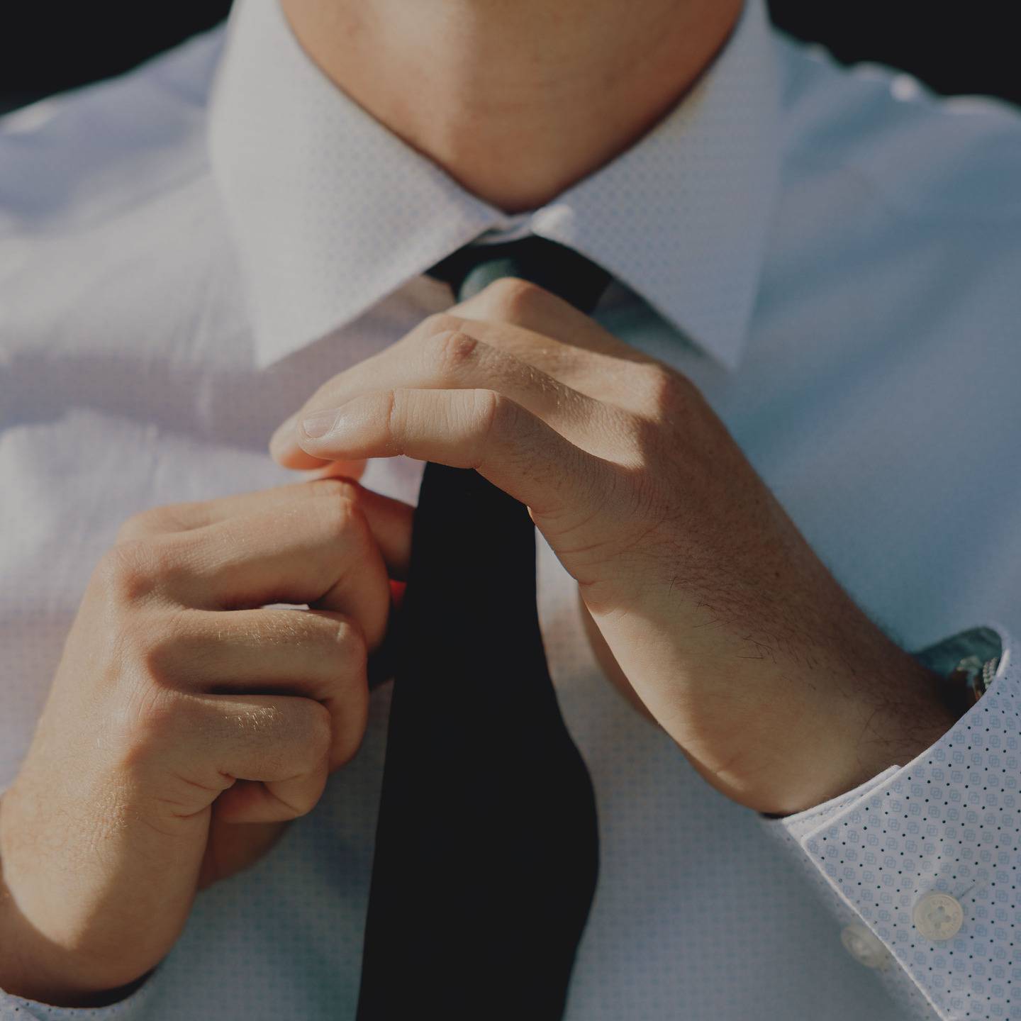 a person tying a tie