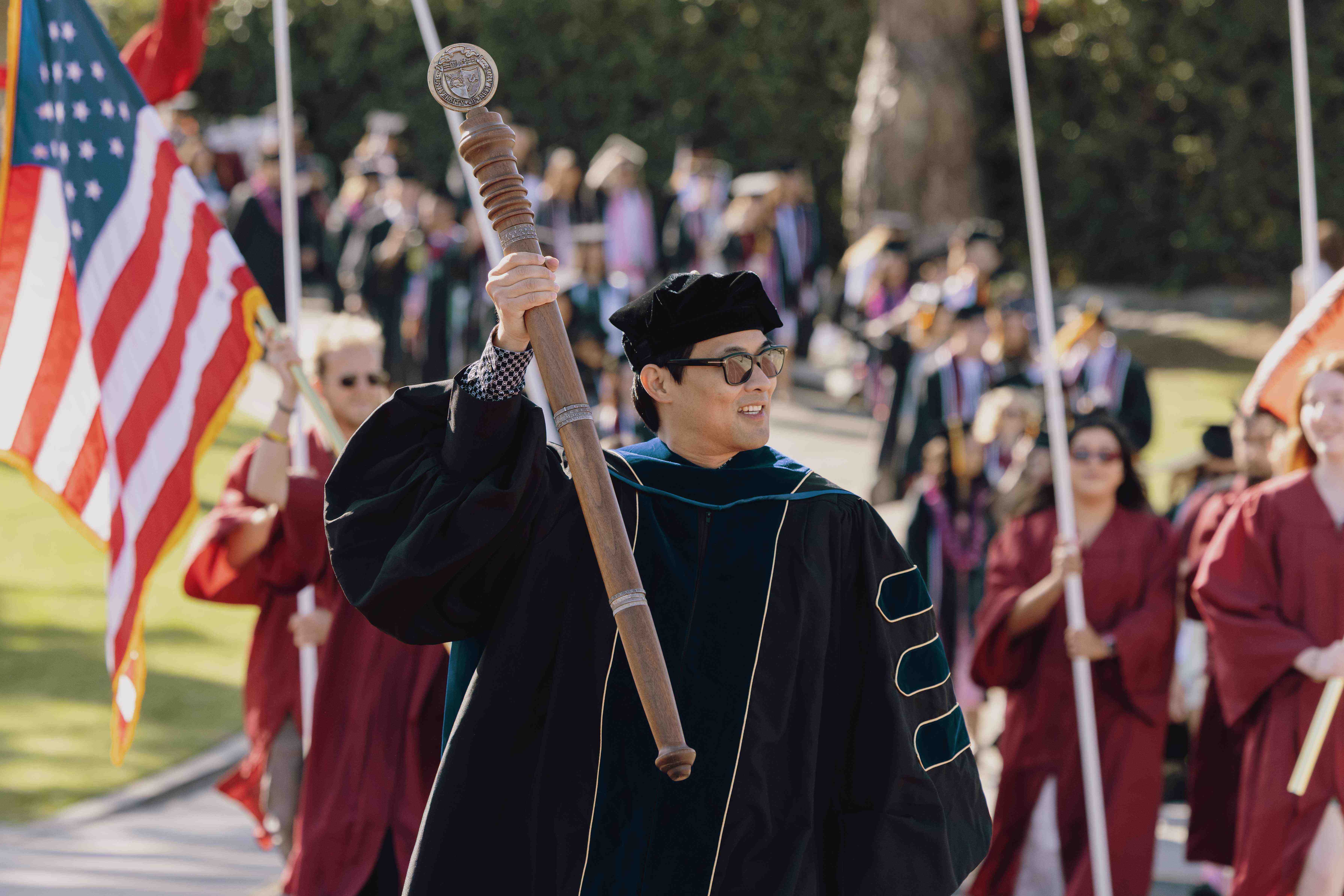 a person in a black robe holding a baton