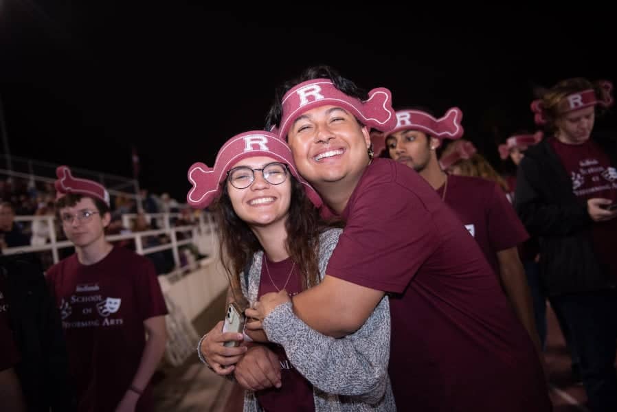 a person hugging a person with a hat on