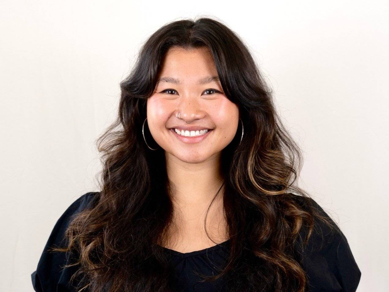 a person with long hair smiling