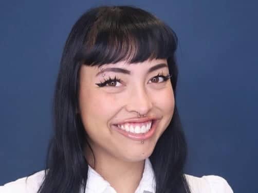 a person with piercings and nose ring smiling