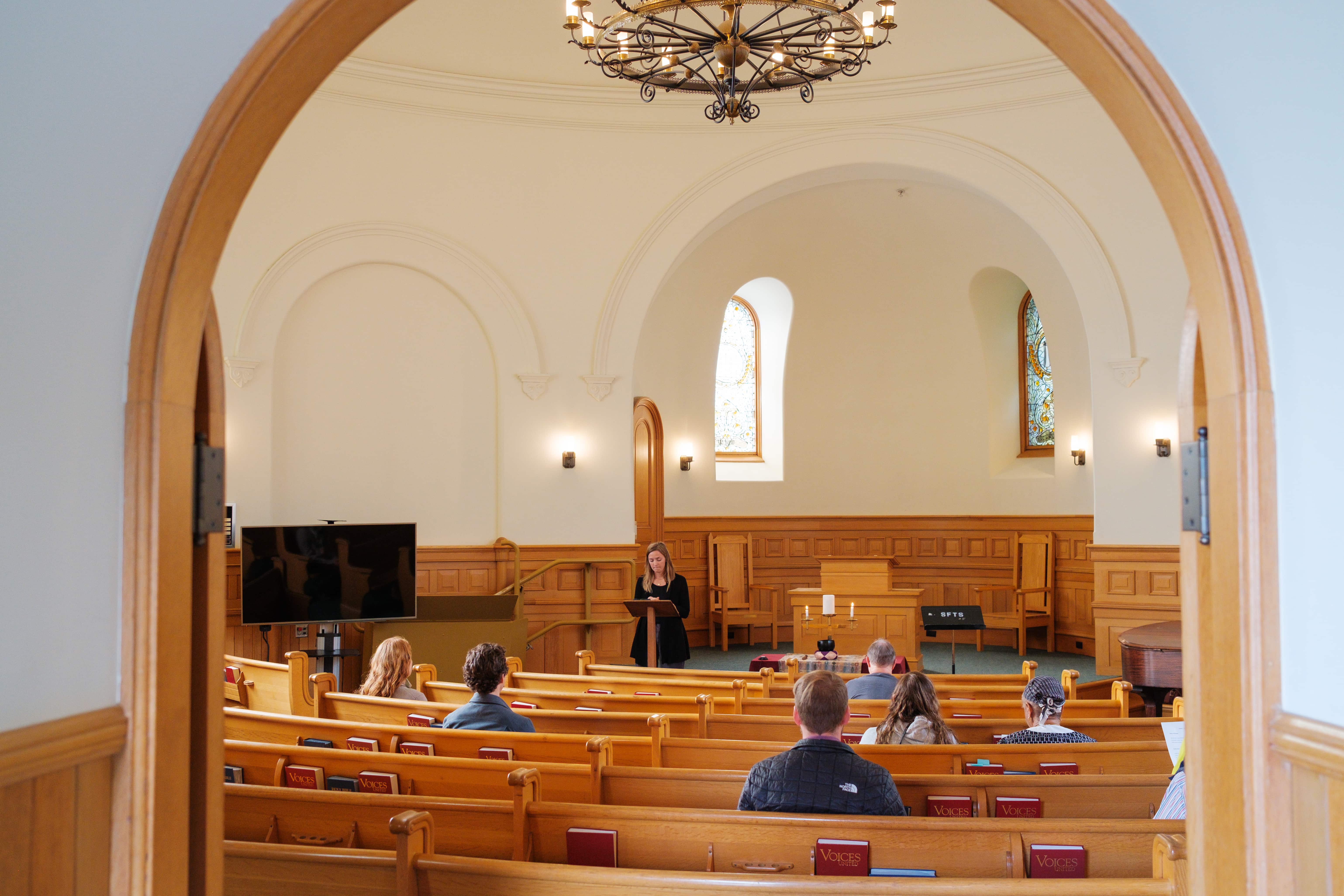 a person standing in a room with a crowd of people