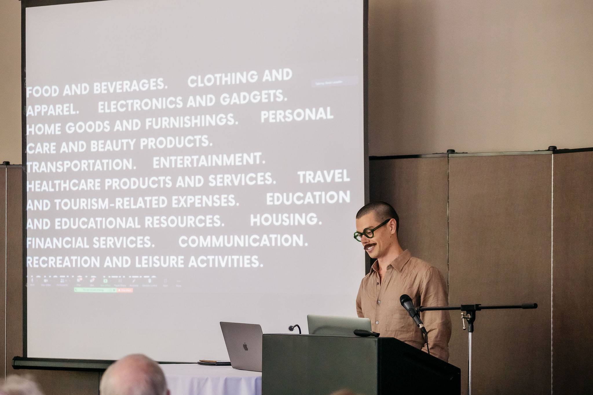 a person standing at a podium with a screen behind him