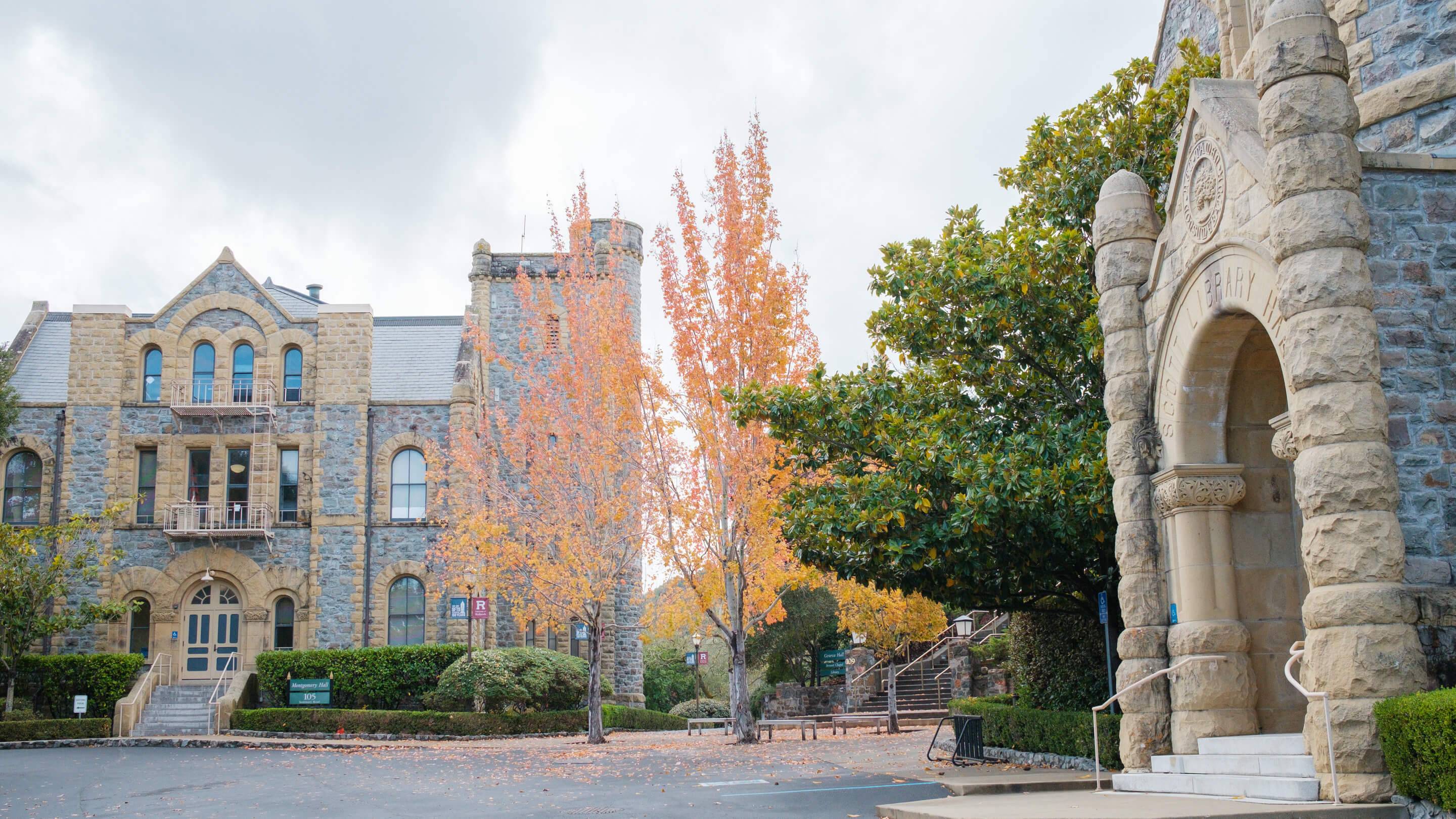 a stone building with trees and a stone column