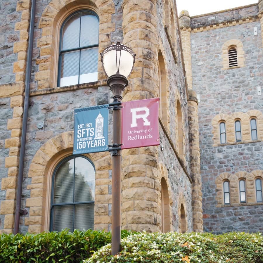 a street light in front of a stone building