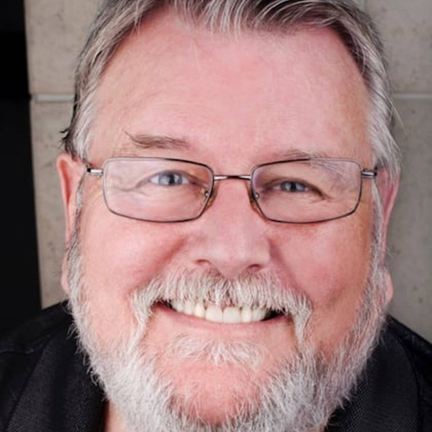 a person with glasses smiling