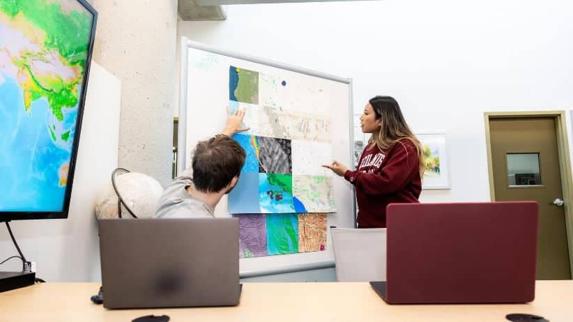 a person pointing at a map on a whiteboard