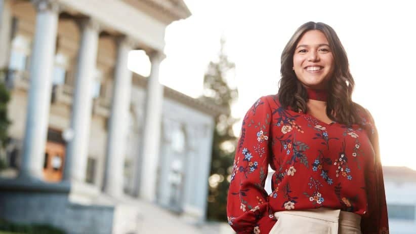 a person smiling in front of a building