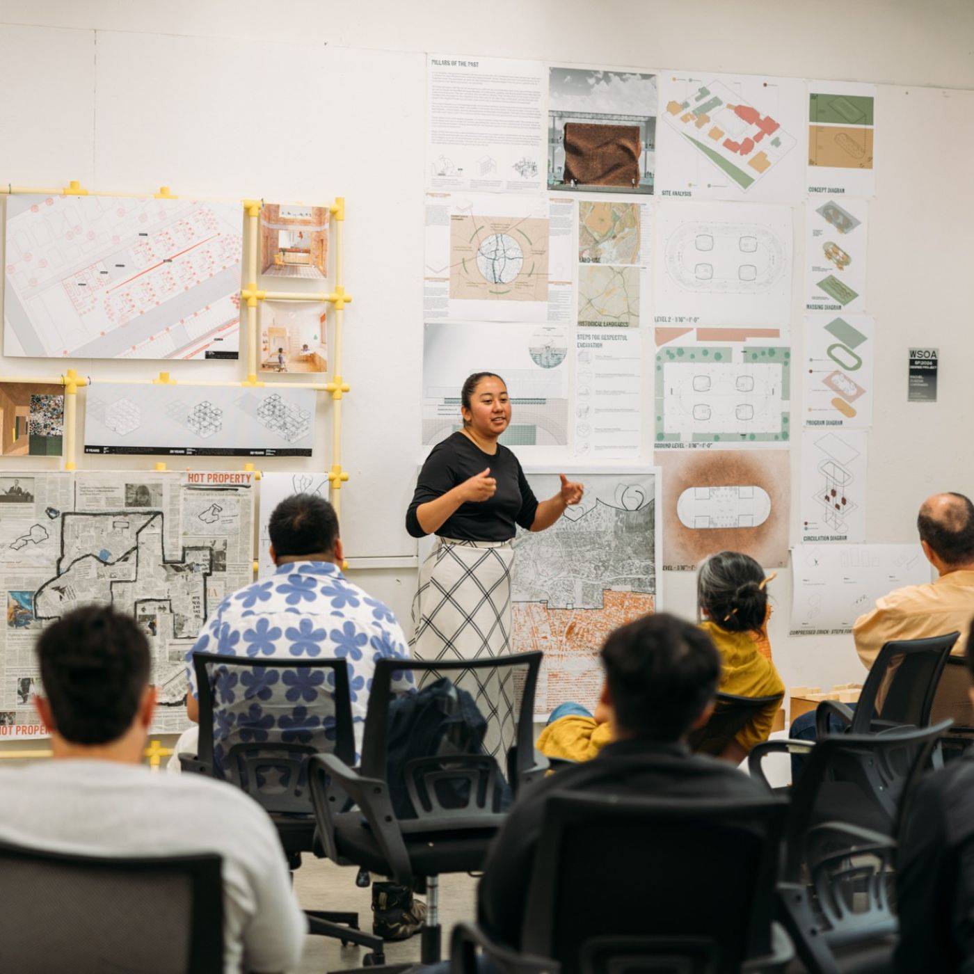 a person standing in front of a group of people in a classroom