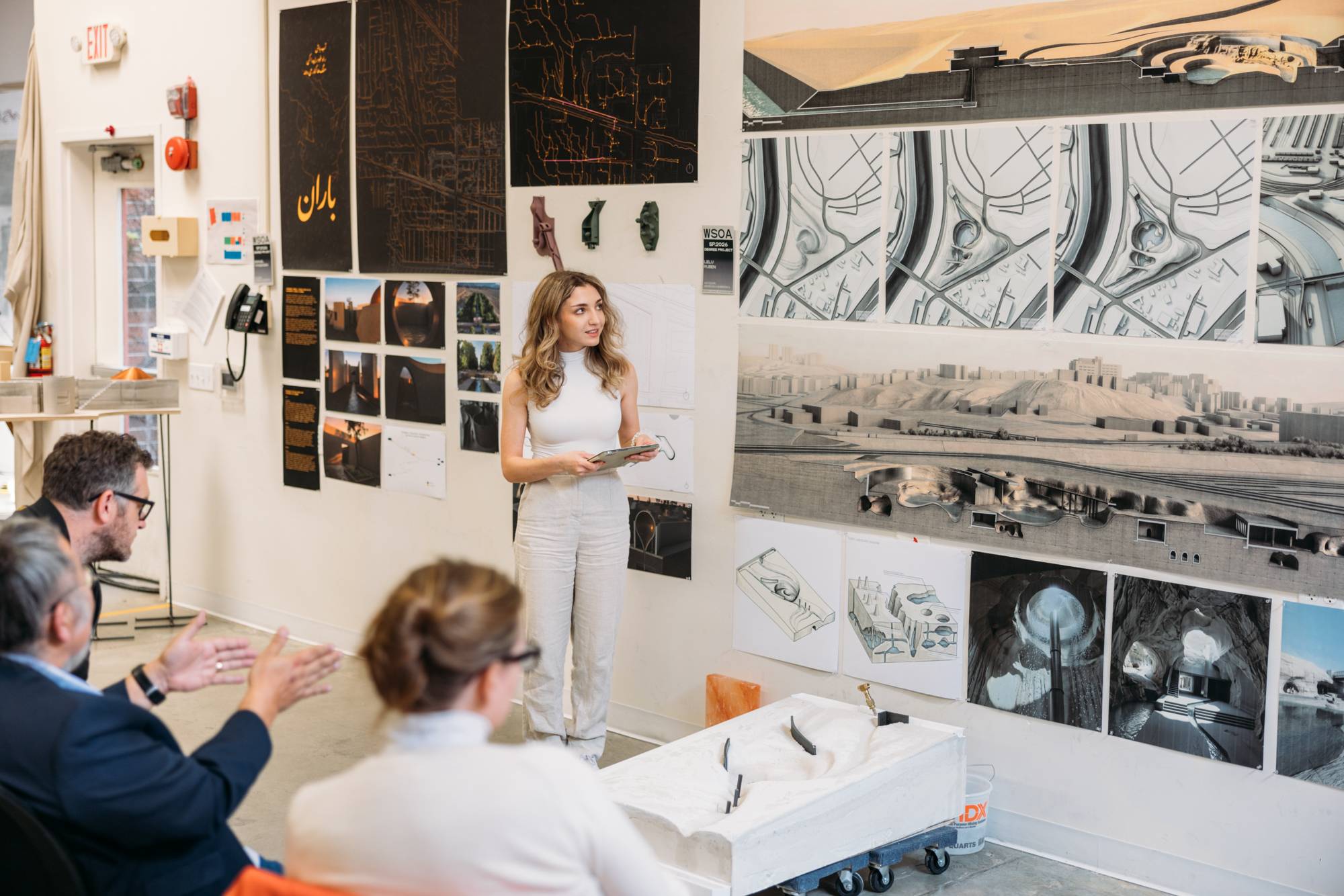 a person standing in front of a wall with pictures on it