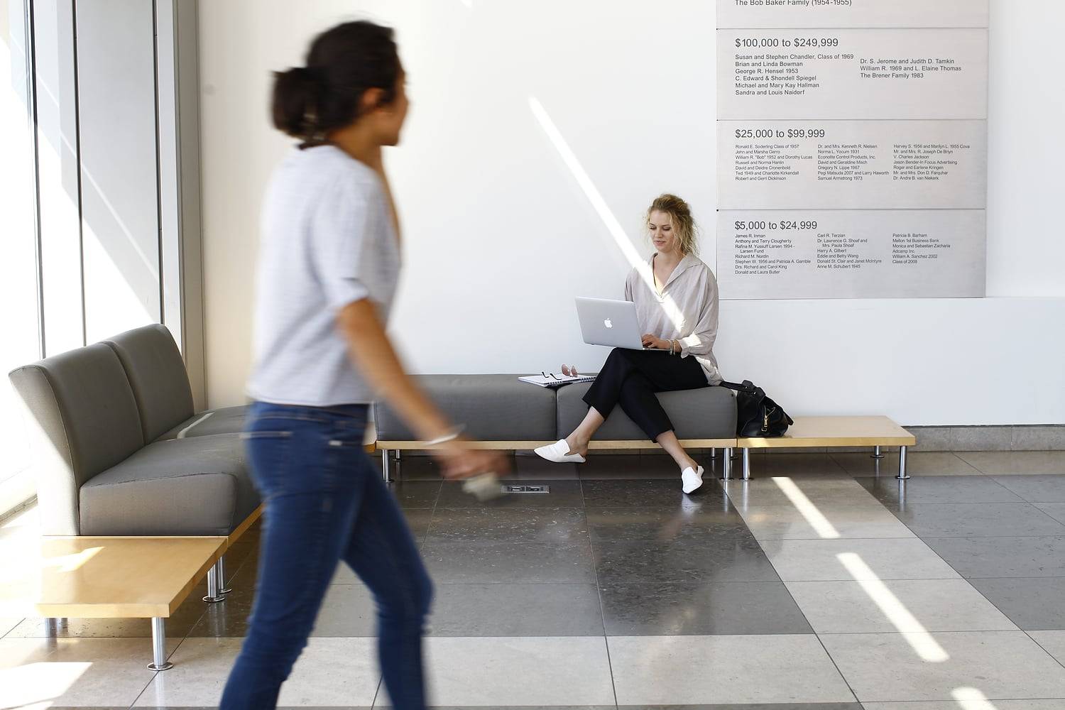 a person sitting on a bench with a laptop