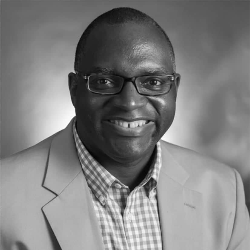 a person wearing glasses and a suit